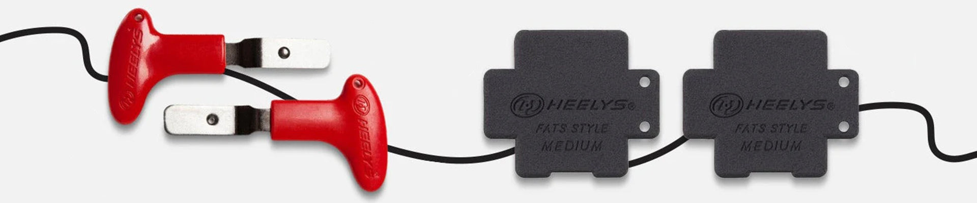 Heelys Accessories. Two Heelys wheel removal tools sit next to two plugs for Heelys roller shoes.